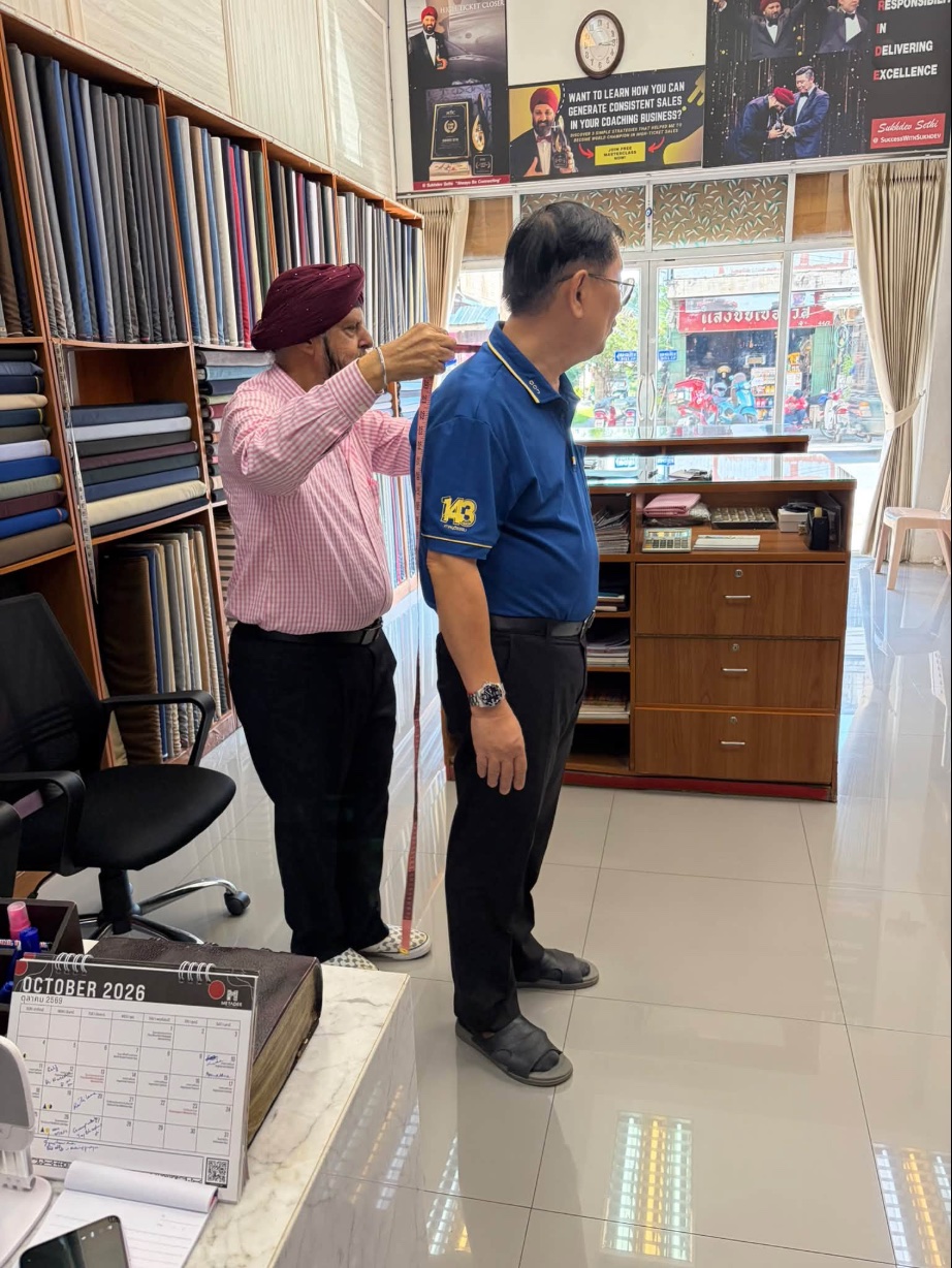 Frank measuring a customer in the Fashion King shop, Chiang Mai
