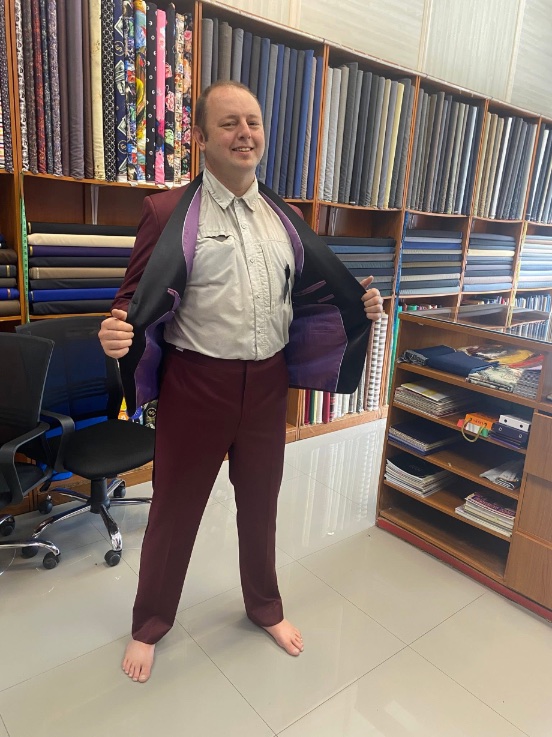 A customer showing the purple lining of his burgundy suit